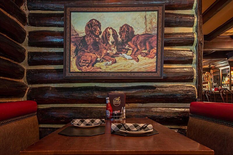 Dining room booth with view of painting of dogs on wall